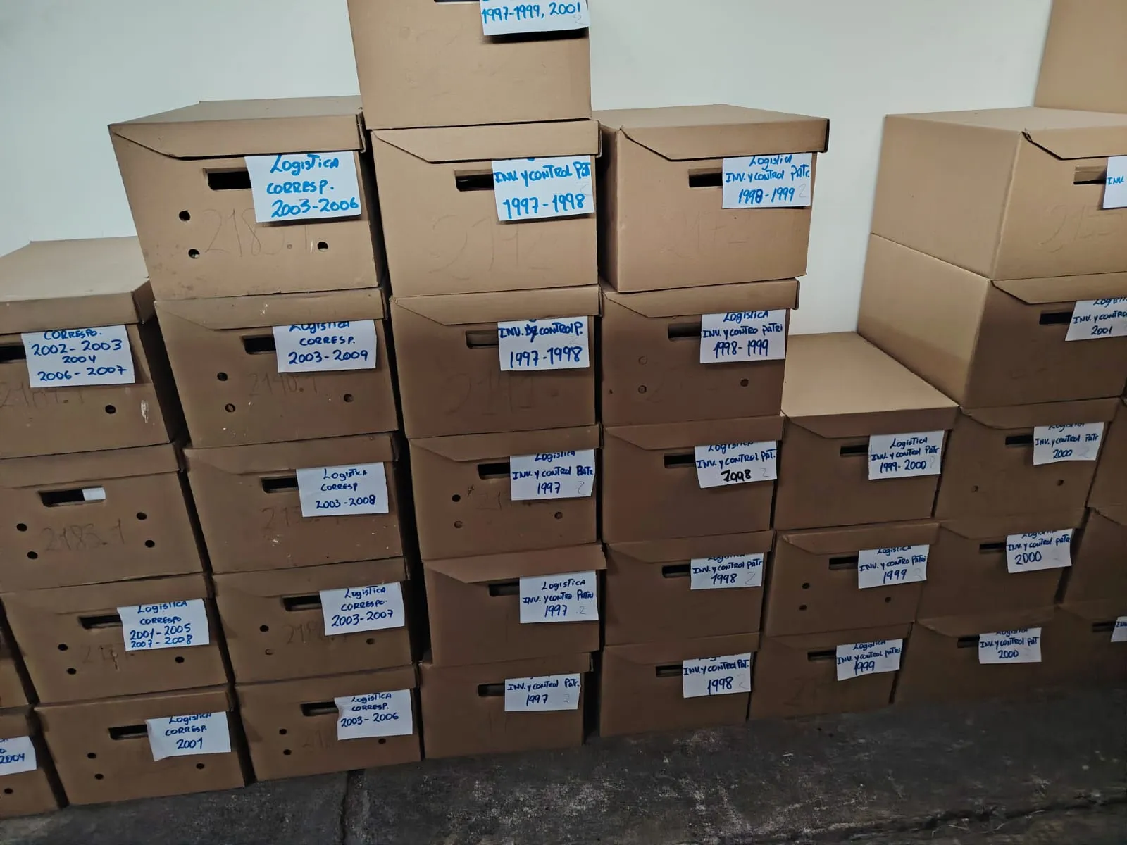 Cajas de archivo rotuladas por área, serie documental y años, listas para su valoración